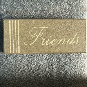 A “friends” wall decor roughly 8”w x 3”h